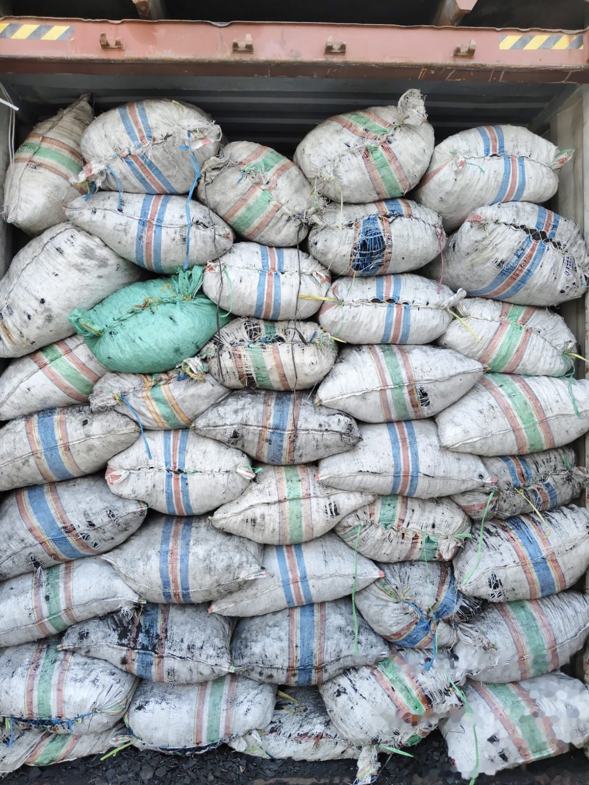 Bagged coconut shell charcoal loaded inside a shipping container